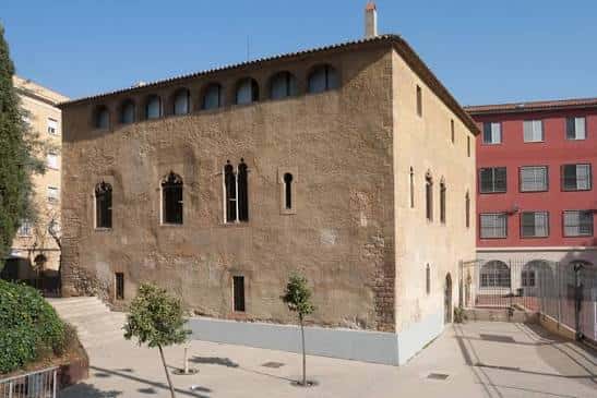 Vista exterior del edificio histórico del Centre Cívic Torre Llobeta con fachada de piedra y ventanas góticas
