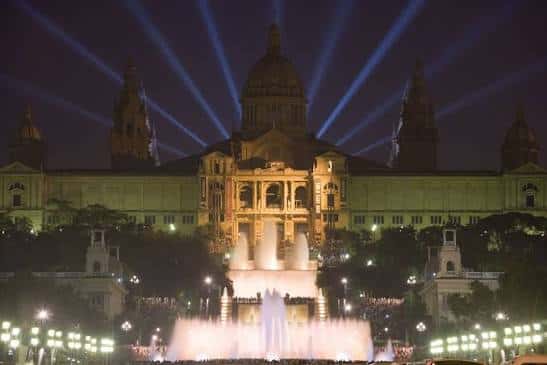 Espectáculo nocturno de la Font Màgica con luces de colores proyectadas sobre el Palau Nacional
