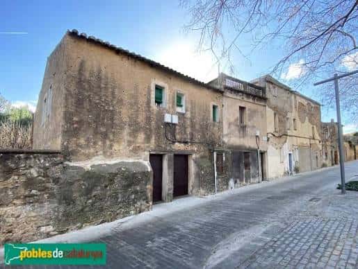 Edificio tradicional de piedra con ventanas verdes en la calle Carrer d'Alarcón