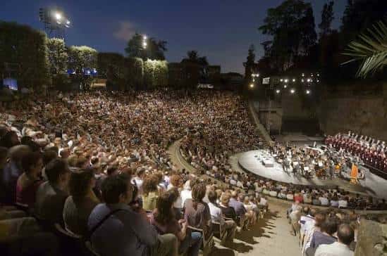 Vista nocturna del Teatre Grec lleno de público durante una actuación