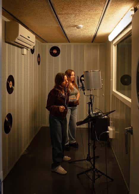 Interior de sala de karaoke con dos personas cantando
