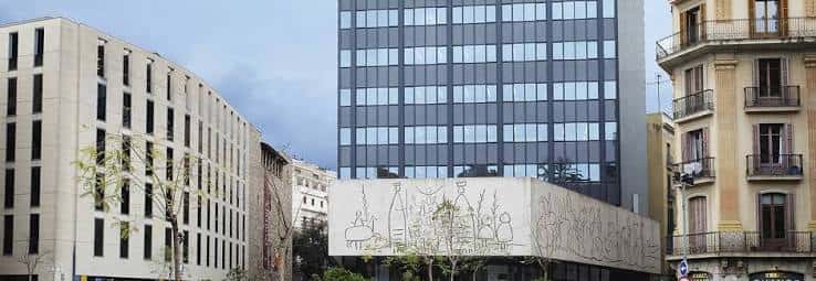 Vista exterior del Centre Obert d'Arquitectura mostrando su fachada moderna y el edificio histórico adyacente