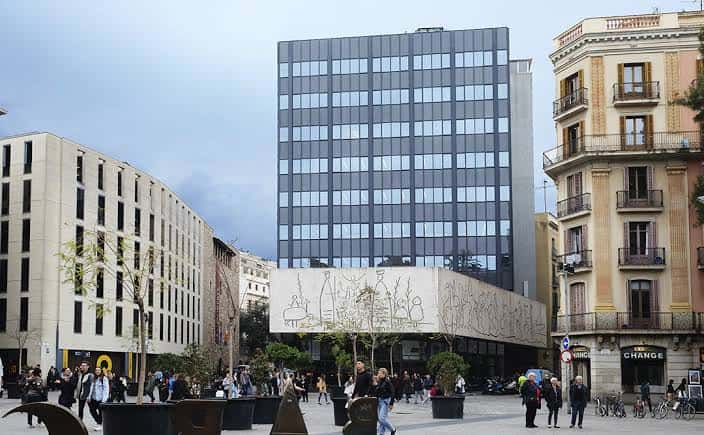Plaza frente al Centre Obert d'Arquitectura con actividad peatonal y arquitectura urbana de Barcelona