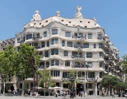Fachada principal de La Pedrera con balcones ondulantes y árboles en primer plano