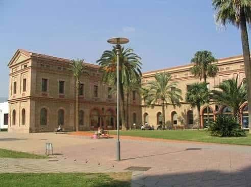 Vista exterior de la Biblioteca Nou Barris con palmeras y plaza
