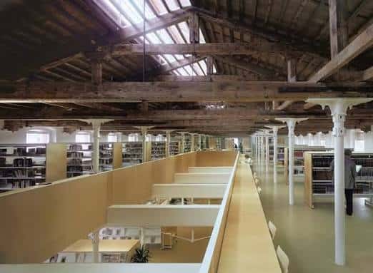 Interior de la Biblioteca Vapor Vell con techos de madera y estanterías