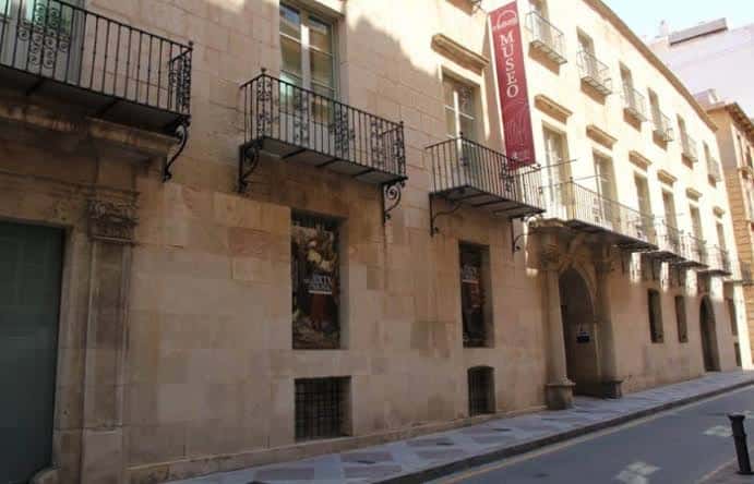 Vista lateral del edificio del MUBAG con cartel de museo y ventanas decoradas