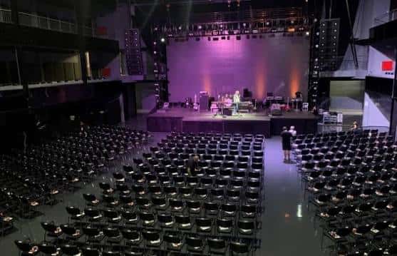 Sala de conferencias o evento corporativo con butacas dispuestas y escenario