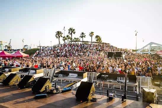 Vista panorámica del Auditorio Marina Norte durante un concierto al atardecer, con el escenario y la grada llena de público