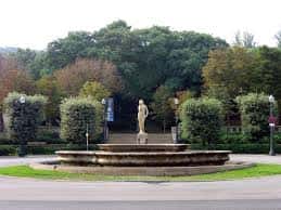 Fuente central con estatua y setos bien cuidados en el jardín