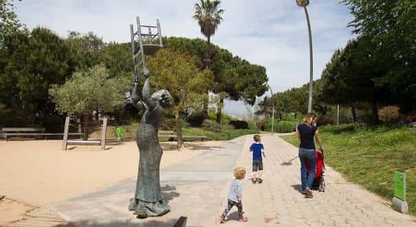 Escultura de la mujer con la silla en el sendero principal del parque
