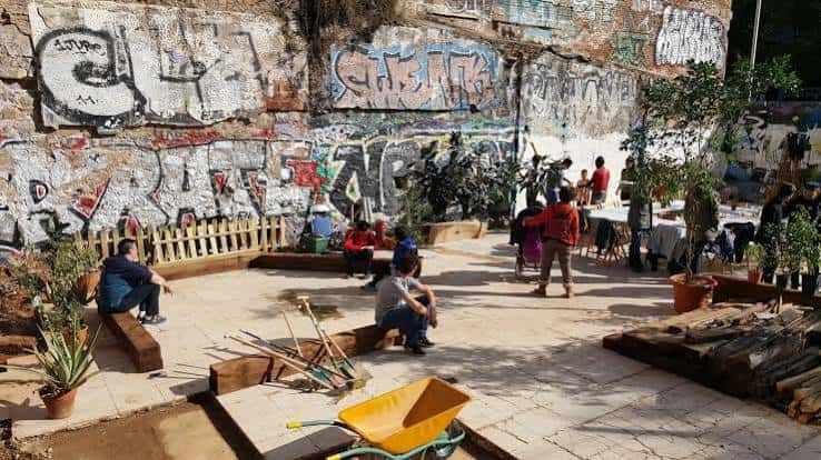 Espacio exterior con murales de graffiti y zona de convivencia