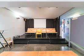 Escenario interior con butacas y cortinas negras