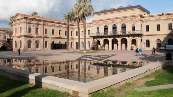 Vista panorámica de la Plaça Major de Nou Barris con edificio histórico y reflejo en el estanque