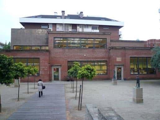 Vista exterior de la fachada de la Biblioteca Clarà con su arquitectura de ladrillo y patio