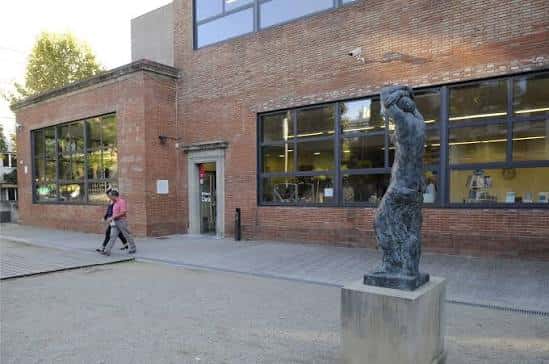 Detalle de la entrada principal de la biblioteca con escultura en primer plano