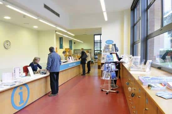 Interior de la biblioteca mostrando el mostrador de información y zona de lectura