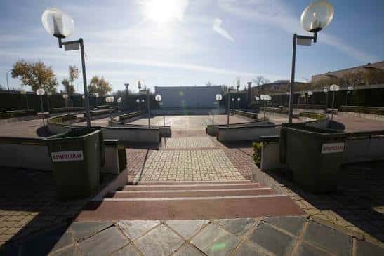 Plaza de acceso al auditorio con escalinatas y farolas decorativas bajo el sol
