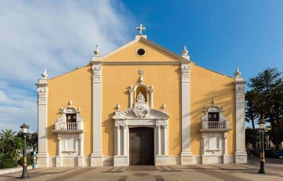 Fachada principal del Santuario de Santa María de África en Ceuta, con su distintivo color amarillo y detalles arquitectónicos blancos