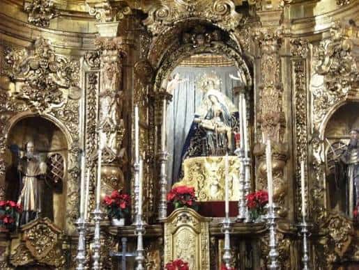 Primer plano del retablo barroco dorado con la estatua de la Virgen de África en el centro