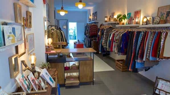 Interior acogedor de la tienda vintage con ropa colgada y decoración artística