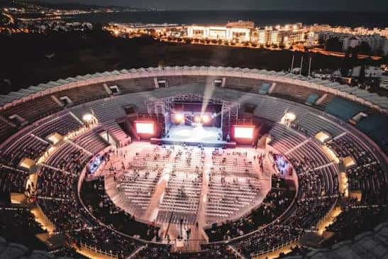 Interior del recinto durante un concierto con escenario iluminado y público