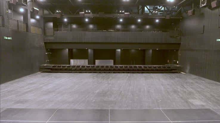 Espacio multifuncional del centro con suelo de madera y estructura superior para eventos culturales o congresos