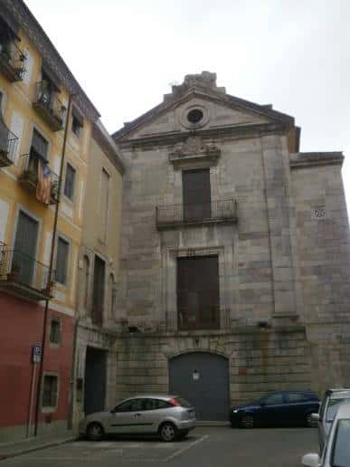 Vista frontal del edificio histórico del Arxiu Municipal de Girona con arquitectura de piedra y balcón central