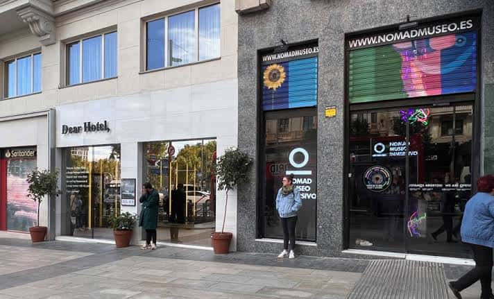 Fachada del Nomad Museo Inmersivo en la calle con letreros luminosos