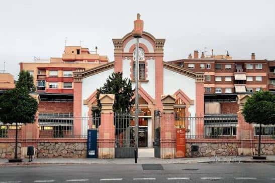 Exterior de la biblioteca desde la calle, mostrando su fachada simétrica y entorno urbano