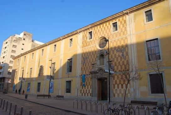 Fachada principal de la Casa de Cultura de Girona con diseño geométrico en tonos amarillos y entrada monumental