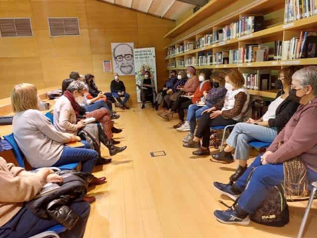 Evento cultural en la biblioteca con público asistente