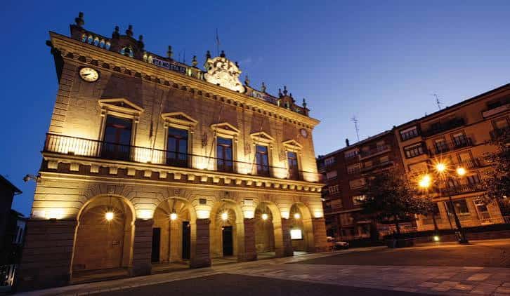 Vista nocturna iluminada del edificio histórico de la plaza, ideal para eventos al atardecer