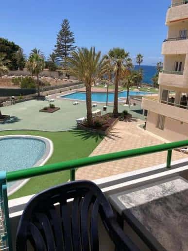 Vista desde un balcón hacia las piscinas y el mar