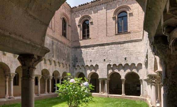 Claustro del monasterio con arcos de medio punto, columnas y jardín central