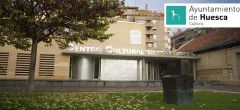 Fachada lateral del centro cultural con vegetación en primer plano