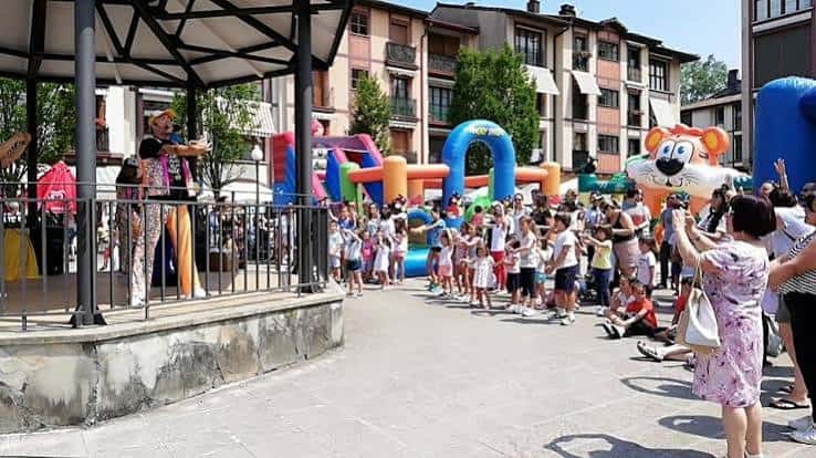 Celebración de fiestas en la plaza con público y atracciones infantiles