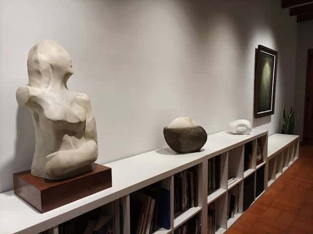 Escultura de una figura humana en un pedestal dentro de la galería