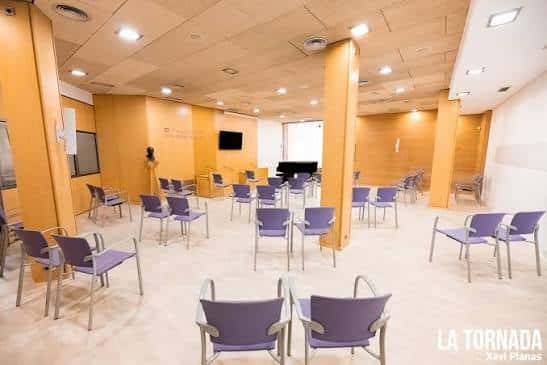 Sala de eventos con sillas púrpuras y piano en el interior