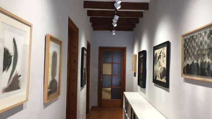 Pasillo de la galería con obras de arte enmarcadas en las paredes