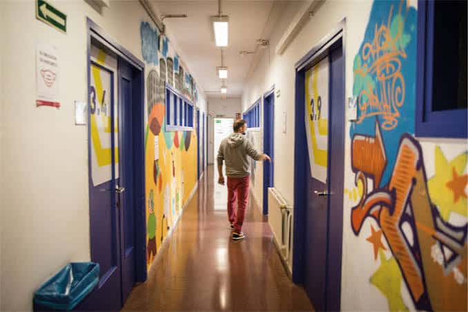 Pasillo interior decorado con grafitis y murales artísticos
