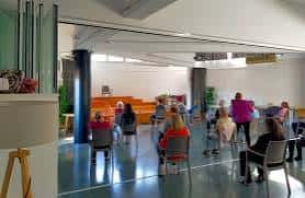 Interior del hall del centro social con personas reunidas en círculo