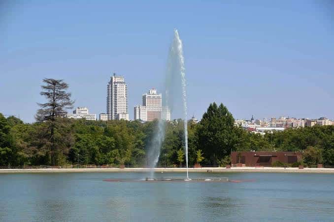 Fuente en el lago de Casa de Campo con skyline de Madrid al fondo