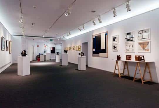 Interior de la sala con exposiciones de arte y vitrinas