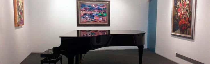 Sala con piano de cola y obras de arte enmarcadas