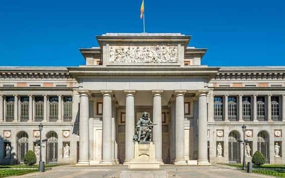 Vista frontal del Museo del Prado bajo cielo azul despejado