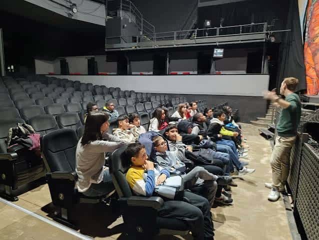 Interior del auditorio mostrando butacas y grupo de personas en sesión o presentación
