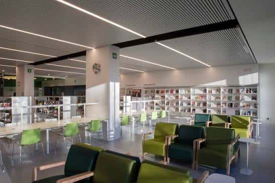 Interior de la biblioteca con estanterías y zonas de lectura