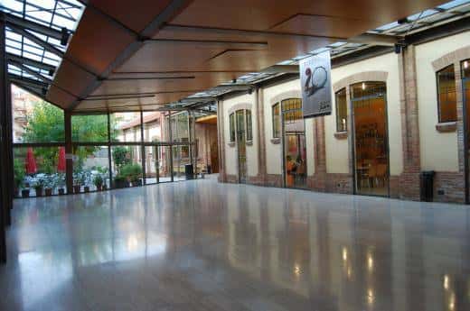 Espacio interior amplio con suelo pulido, techos altos y acceso a zonas exteriores