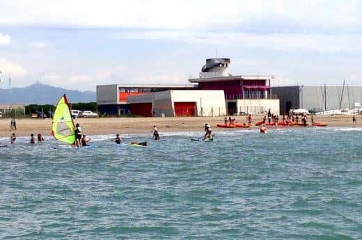 Vista panorámica del centro desde la playa con deportistas practicando vela